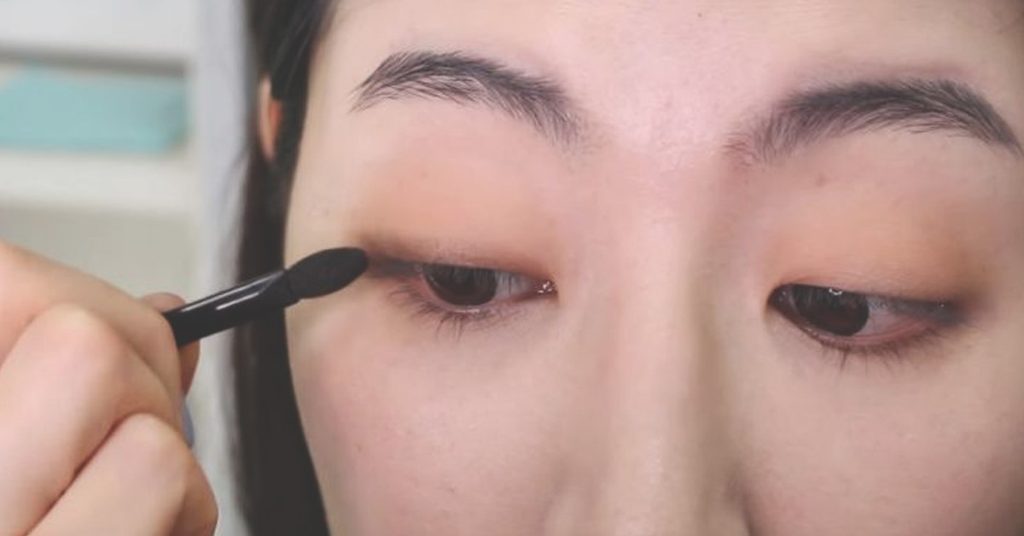 用深色眼影貼近睫毛根部，營造自然偽眼線效果